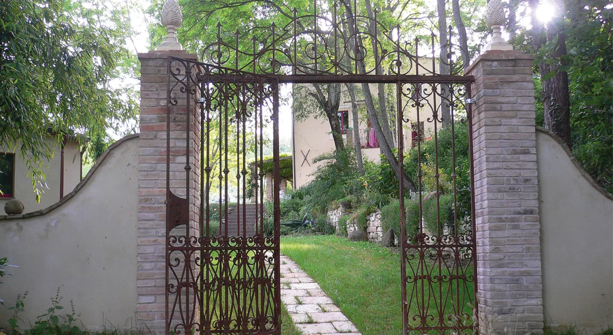 Cancello in ferro battuto con vista sul giardino di Villa Castelplanio